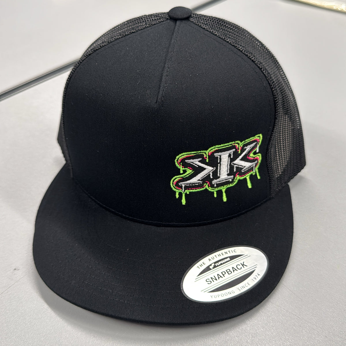 YUPOONG FLAT BILL TRUCKER K.I.K. DRIP LOGO SNAPBACK